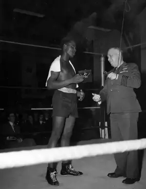CAPT Fisher presenting Boxing Smoker Award to J Williamson November 16, 1944