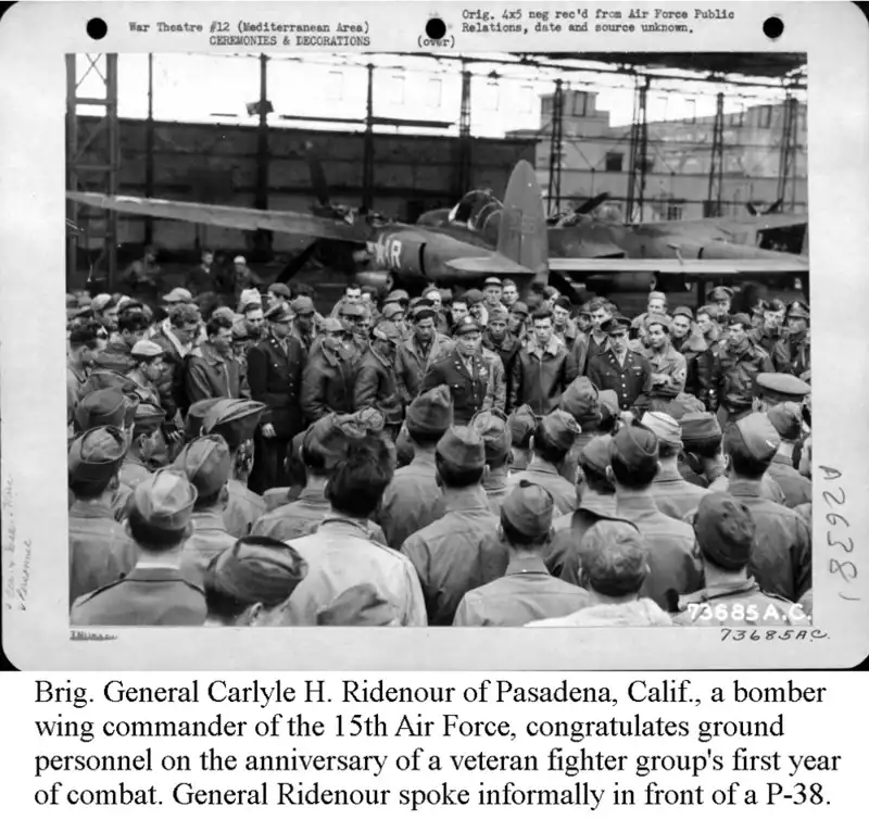 Brig General CH Ridenaur congratulates ground personnel on the anniversity of a veteran fighter groups first year of combat. He spoke informally in front oh a P-38